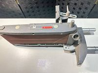 Full view of Shopsmith belt sander attachment showing belt, dust port, and mounting posts