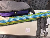Overall lot showing Glacier Gear bag, Tommy Bahama umbrella in sleeve, three compact umbrellas