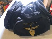 Front view showing Bon Jovi logo on black canvas duffel