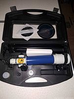 Open carrying case showing telescope tube, tripod, eyepieces, diagonal, cap and software CD