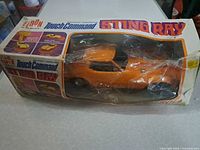 Front view of boxed Eldon Sting Ray car showing orange car through torn plastic window