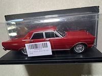 Side view of red 1965 Ford die-cast car inside display box