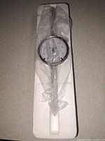 Dial indicator sealed in plastic on foam insert
