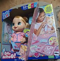 Front of sealed Baby Alive Lulu Achoo box showing doll and accessories