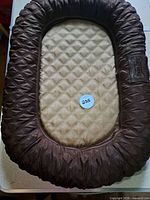Top view of brown and beige quilted oval dog bed