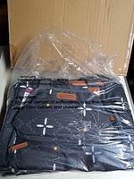 Tote set sealed in plastic with box behind