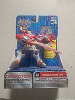 Front view of sealed Digimon Shoutmon X4 figure in package