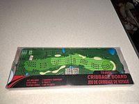 Front of sealed box showing foldable cribbage board with golf design