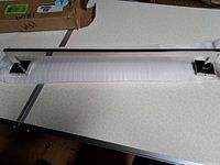 Full view of chrome towel bar resting on packing foam