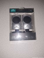 Front view of sealed package showing both speakers inside