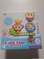 Front of boxed Happy Bath Time set showing all four toy components and age 3 + label