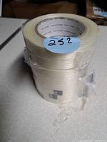 Stack of multiple clear filament tape rolls showing width and translucent color