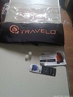 Folded TravelQ bag with logo, instruction sheet, plugs, header card
