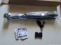 Boxed UBeeSize selfie stick tripod set with tripod in plastic, phone mount and adapter visible