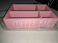 Front view showing pink box with white "COFFEE BAR" text