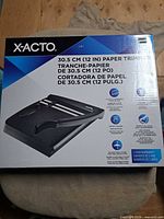 Front of sealed X-ACTO paper trimmer box showing product image and specifications