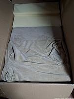 Foam inserts and beige fabric cover inside opened box