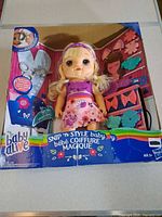 Front of boxed Baby Alive Snip 'n Style Baby doll and accessories