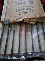 Damaged box opened showing black metal gate panels inside