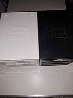 Top view of both white and black Spice Stack units showing embossed brand name