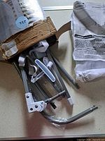 Damaged box showing metal frame parts and hardware straps inside plastic