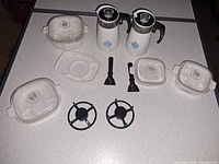 Group shot showing all casseroles with lids, two percolators, handles, trivets, cradle
