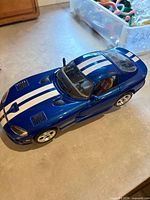 Top view of blue Bburago Dodge Viper GTS Coupe model showing white racing stripes and overall condition