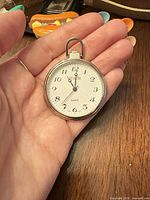 Front view of Episode pocket watch in hand showing dial and hands