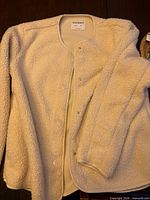 Full view of ivory sherpa fleece jacket front with snaps closed