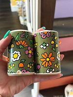 Front view of both shakers showing floral design and chip at base
