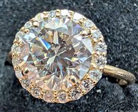 Top view showing round center diamond and halo of accent diamonds in yellow gold setting