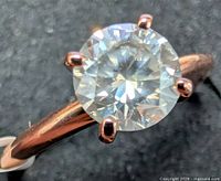 Close view of round brilliant diamond in six-prong rose gold setting