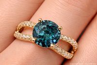 Ring on finger showing blue centre diamond and split-shank pavé band