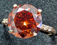 Top view of ring showing orange lab diamond and accent stones
