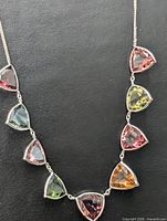 Full view of necklace showing chain and multi-colour trilliant tourmaline settings