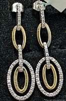 Front view of both diamond drop earrings on black background
