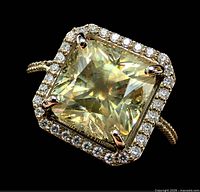 Top view showing square-cut center diamond, halo of accent diamonds, prongs and portion of band