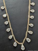Full view of gold necklace with teardrop diamond stations