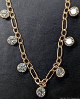 Full view of necklace showing gold links and bezel-set moissanites