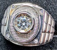 Top view showing center diamond, accent stones, textured bezel and band design