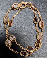 Full view of bracelet showing double chain and bezel-set coloured diamonds