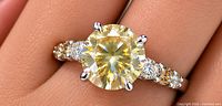 Ring on finger showing overall design and diamond arrangement