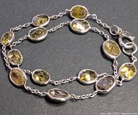 Entire bracelet laid flat showing double strands and bezel-set coloured diamonds