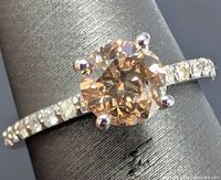 Oblique view of ring showing center cognac diamond and shoulder accent diamonds