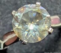 Round brilliant fancy diamond in six-prong gold setting close-up