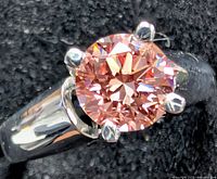 Close-up of ring showing pink diamond and prong setting