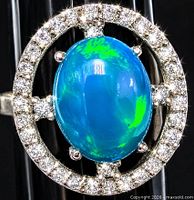 Front view showing opal cabochon and diamond halo setting