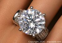 Ring on finger showing round centre diamond and baguette accents