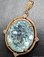 Front view of pendant showing aquamarine, diamonds and gold frame