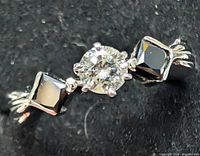 Top view of platinum ring showing round center diamond and square accent diamonds
